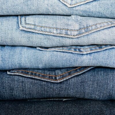 Closeup of stack of blue denim pants neatly arranged according to color from lightest to darkest