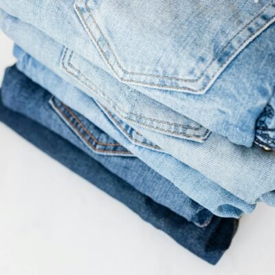 Stack of jeans on white marble surface